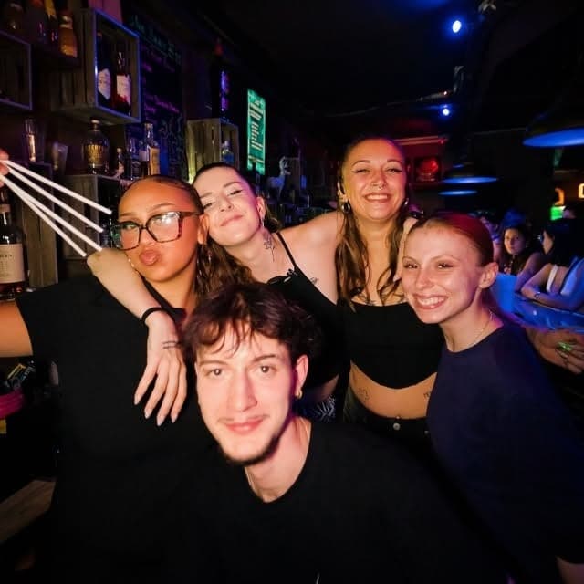 Un groupe d’amis devant le comptoir et les bouteilles du bar